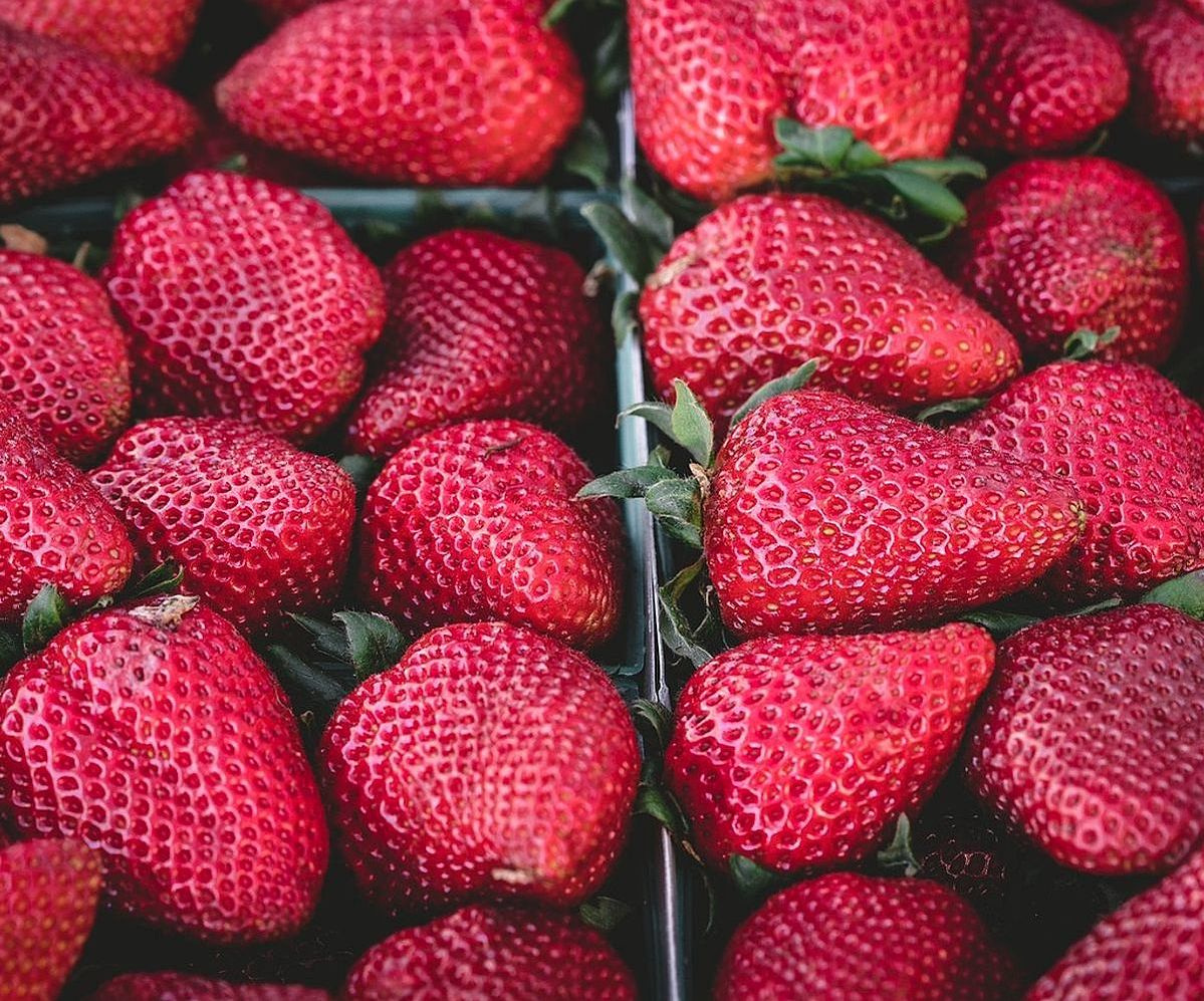 El mostrador rebosante de frutas frescas y bayas coloridas